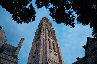 Harkness Tower rises dramatically into the darkening sky at dusk